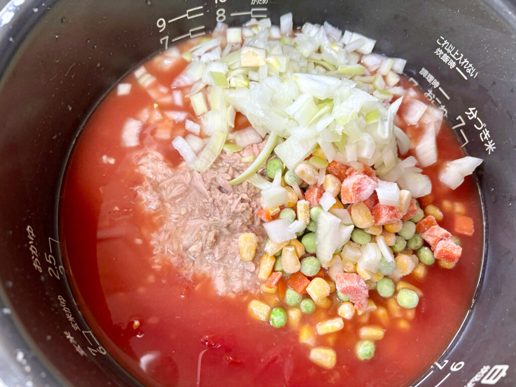 玉ねぎやミックスベジタブル、ツナを炊飯器にいれていく