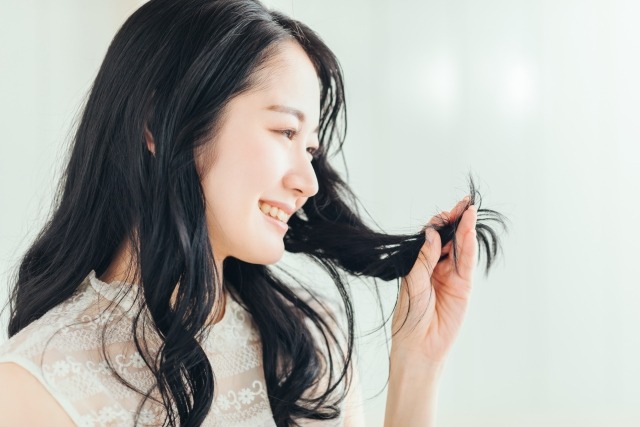 髪の日焼け対策をする女性